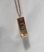 A 9ct yellow gold ingot, on a yellow metal chain marked 9ct,