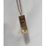 A 9ct yellow gold ingot, on a yellow metal chain marked 9ct,