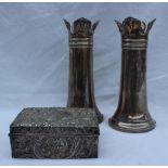 A pair of George V silver vases with a shaped top and tapering cylindrical column on a spreading