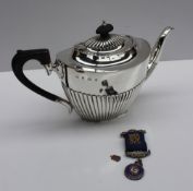 A late Victorian silver teapot of oval form with a half gadrooned body , Birmingham, 1900,