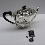 A late Victorian silver teapot of oval form with a half gadrooned body , Birmingham, 1900,
