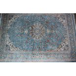 A Turkish room size rug, with a light blue ground decorated with flower heads and leaves,