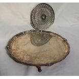 A George V silver salver, with a shaped and floral border, signed to the plate, on three feet,