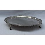 A George V silver salver, with a beaded edge and four claw and ball feet, 21cm diameter, Sheffield,