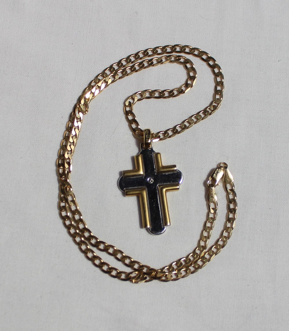 An 18ct yellow gold cross set with a single round brilliant cut diamond approximately 0.