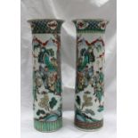 A pair of Chinese Famille Verte vases of cylindrical form with a flared rim decorated with figures