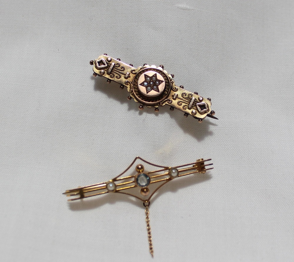 A Victorian 9ct yellow gold bar brooch, the central star set with seed pearls,