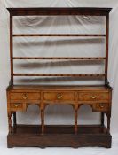 A South Wales oak dresser, the moulded cornice above three shelves, the base with an arrangement