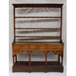 A South Wales oak dresser, the moulded cornice above three shelves, the base with an arrangement