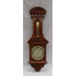 A 20th century carved walnut aneroid barometer carved with a shell and leaves,