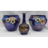 A pair of Wilkinson Ltd pottery jardinieres decorated with flowers and tendrils to a royal blue