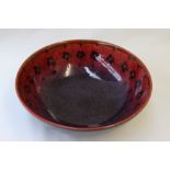 A Royal Doulton flambe Sung bowl decorated with flower heads to a red and purple ground,