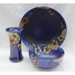 A Wilkinson Ltd pottery bowl, decorated with flowers and tendrils to a royal blue ground,