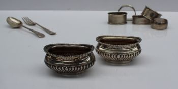 A pair of Edward VII silver table salts, of oval form, Birmingham, 1904, together with napkin rings,