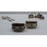 A pair of Edward VII silver table salts, of oval form, Birmingham, 1904, together with napkin rings,