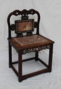 A Chinese hardwood and marble inset chair the back carved with scrolls, leaves and fruit,