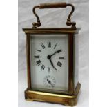 A brass carriage clock, the enamel dial with Roman numerals and an alarm dial,