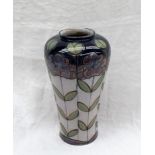 A Royal Doulton stoneware vase decorated with flower heads and leaves to a white ground,