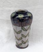 A Royal Doulton stoneware vase decorated with flower heads and leaves to a white ground,