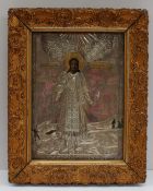 A yellow and white metal icon with painted decoration of a saint standing in a landscape,
