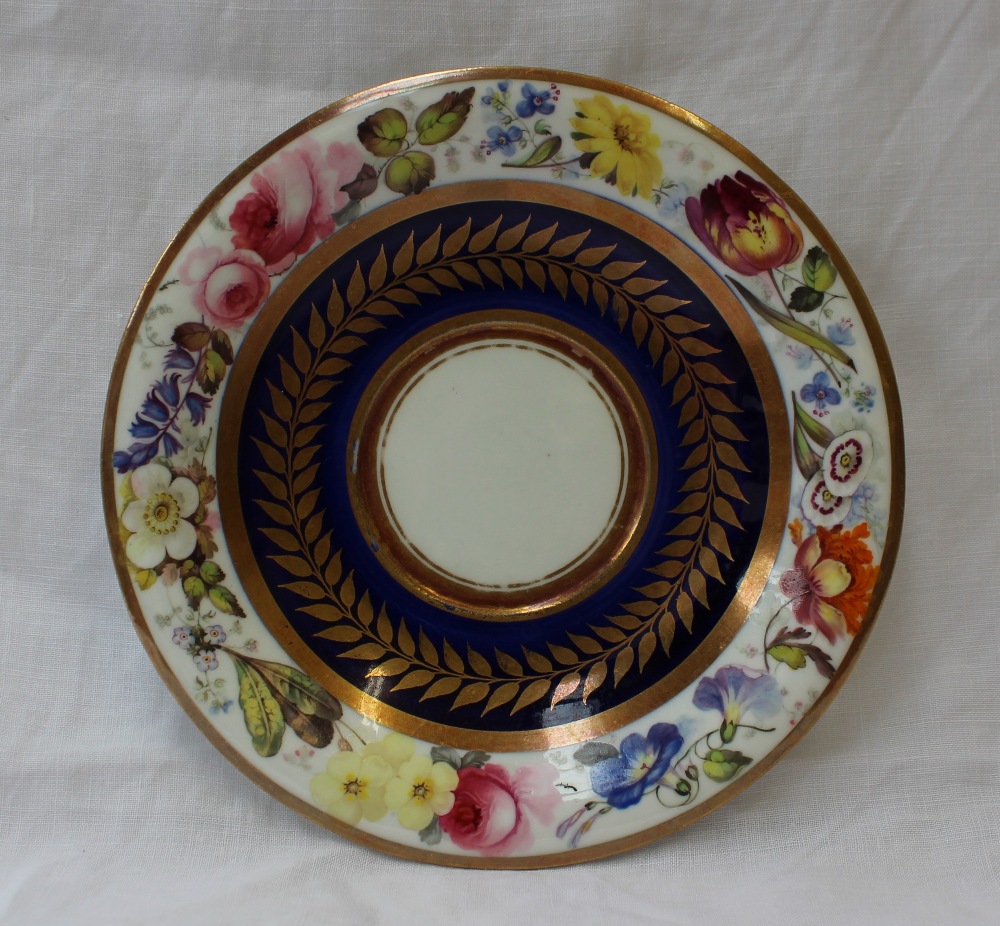 A Swansea porcelain saucer dish, painted to the border with a continuous band of garden flowers,