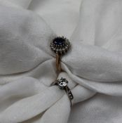 A Sapphire and Cubic zirconium set dress ring the central oval faceted sapphire surrounded by cubic