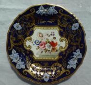 A 19th century English porcelain plate with a thick gilt rim and royal blue ground with raised vine