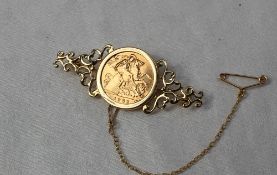 An Elizabeth II gold half sovereign dated 1982, in a 9ct yellow gold brooch mount,