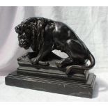 A cast iron model of a lion on a kill, standing on a rectangular plinth, 29.