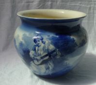 A Royal Doulton blue and white pottery jardiniere decorated with a figure playing a guitar in a