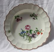 An 18th century English porcelain bowl, with a chocolate line edge and moulded border,