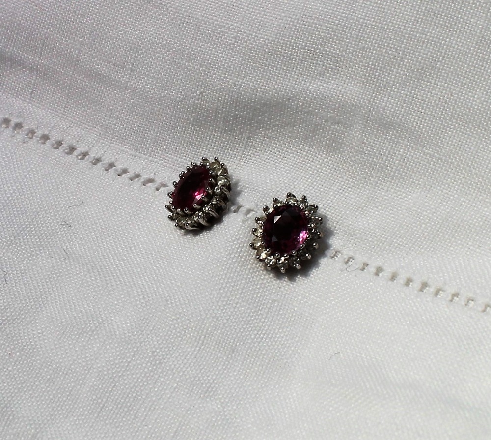 A pair of ruby and diamond cluster ear studs, each set with an oval mixed cut ruby, - Image 2 of 3