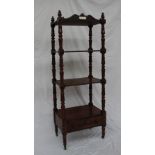 A Victorian rosewood whatnot with turned finials above four shelves and a drawer supported by lotus