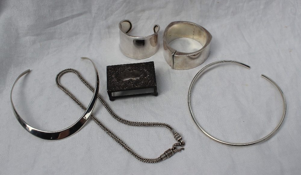 A silver slave bangle together with a silver match box holder, white metal necklaces,