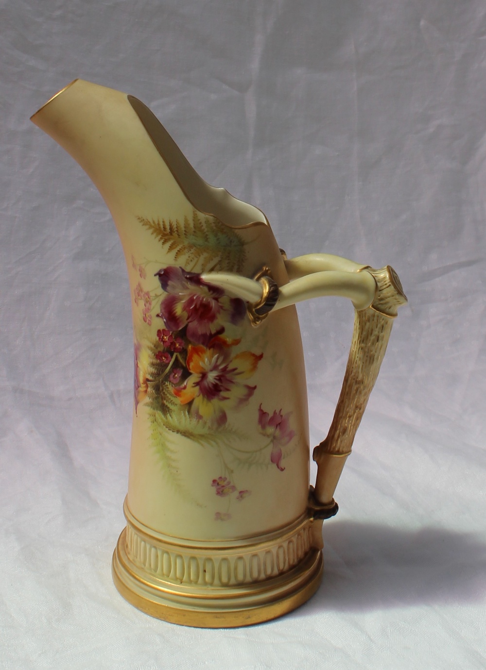 A Royal Worcester porcelain ewer with a faux antler handle transfer and infil decorated with flower