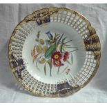 A Derby porcelain plate, the gilt decorated rim with pierced decoration, highlighted in royal blue,
