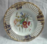 A Derby porcelain plate, the gilt decorated rim with pierced decoration, highlighted in royal blue,