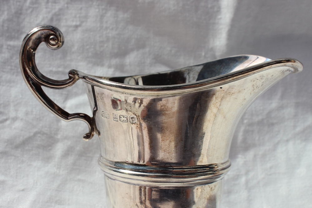 An Elizabeth II silver cream jug of helmet shape, with a ring turned body on a spreading foot, - Image 5 of 7