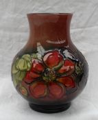 A Moorcroft vase decorated in the clematis pattern, to a graded red ground,