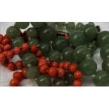 A green jade bead necklace, on a knotted cotton thread with a twist clasp,