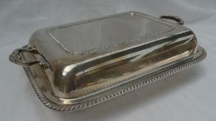 A George V silver entree dish and cover with scrolling handles and a gadrooned edge, Birmingham,