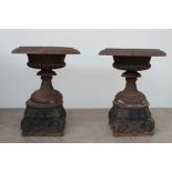 A pair of impressive cast iron urn planters with a flared gadrooned rim,