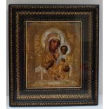 A Romanian gilt and white metal icon depicting the Madonna and child in an ebonised and gilt