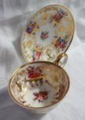 A Nantgarw porcelain breakfast cup and saucer, decorated with gilt vases and garden flowers,