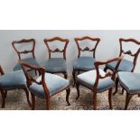A set of six early 19th century rosewood dining chairs with a camel back and pad seat on cabriole