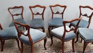 A set of six early 19th century rosewood dining chairs with a camel back and pad seat on cabriole