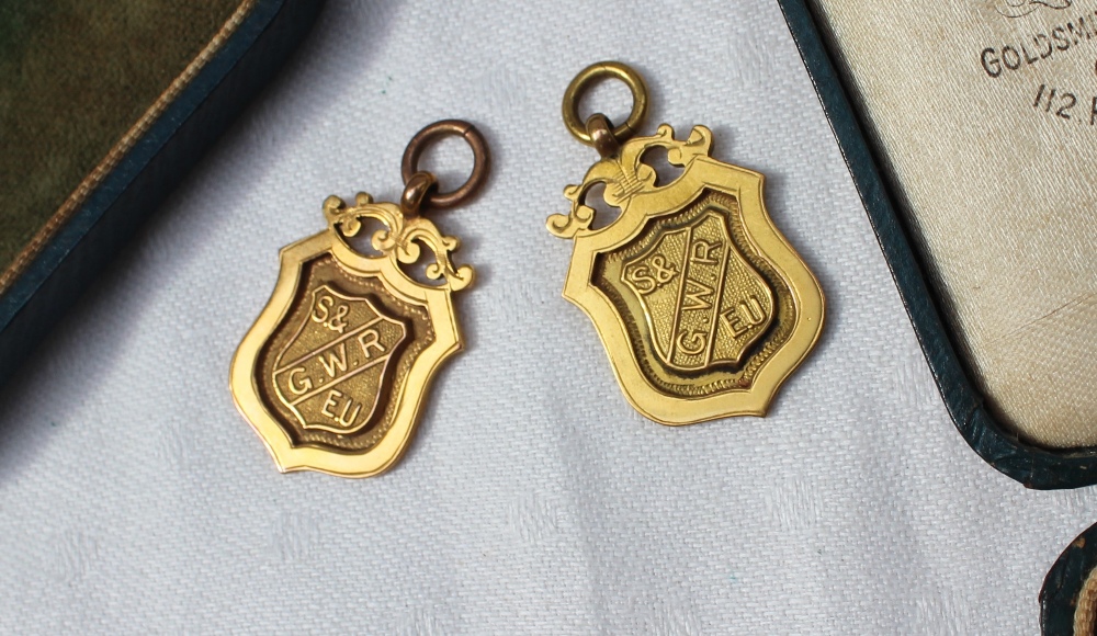 A pair of 9ct medallions, of shield shape with the letters G.W.R. S & E.U.
