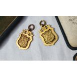 A pair of 9ct medallions, of shield shape with the letters G.W.R. S & E.U.