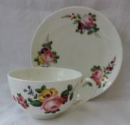 A Nantgarw porcelain tea cup and saucer, painted with sprays of garden flowers,