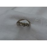 A four stone diamond ring set with four round brilliant cut diamonds in a line,